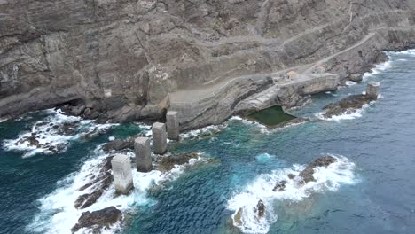 aerial view of sea waves hitting rocks in the natural pools of hermigua on the coast of la gomera