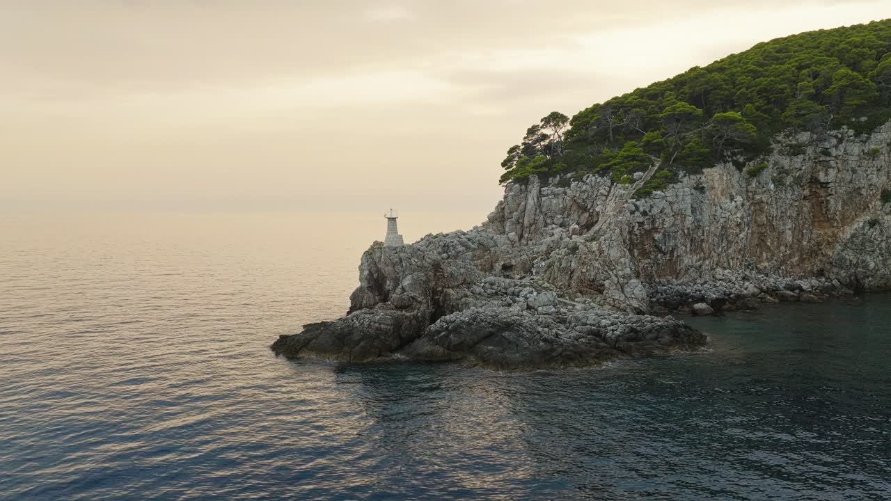 Isola di Kalamota, Mare Adriatico, Croazia - La vista di un faro che poggia su una scogliera frastagliata - Ripresa aerea con drone.