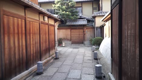 strolling and walking in a beautiful traditional japanese street full of wooden houses and shops early morning without people around