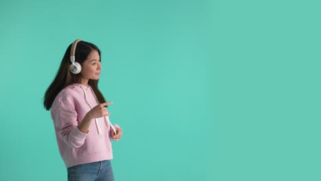 cheerful asian girl in headphones moving to music