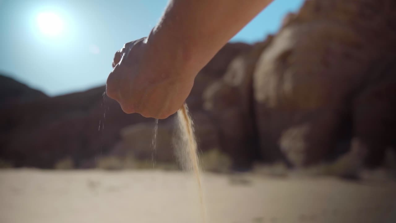 요르단 사막에서 손에서 떨어지는 모래