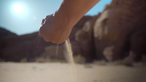 arena cayendo de la mano en el desierto de jordania