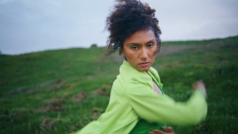 african dancer performing contemporary dance on grass field close up vertically