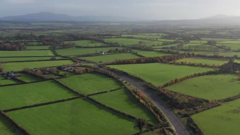 a picturesque aerial view of the lush ireland countryside and an empty highway converging