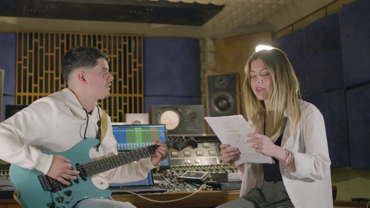 새로운 노래를 녹음하는 동안 음악 스튜디오에서 일하는 두 명의 음악가