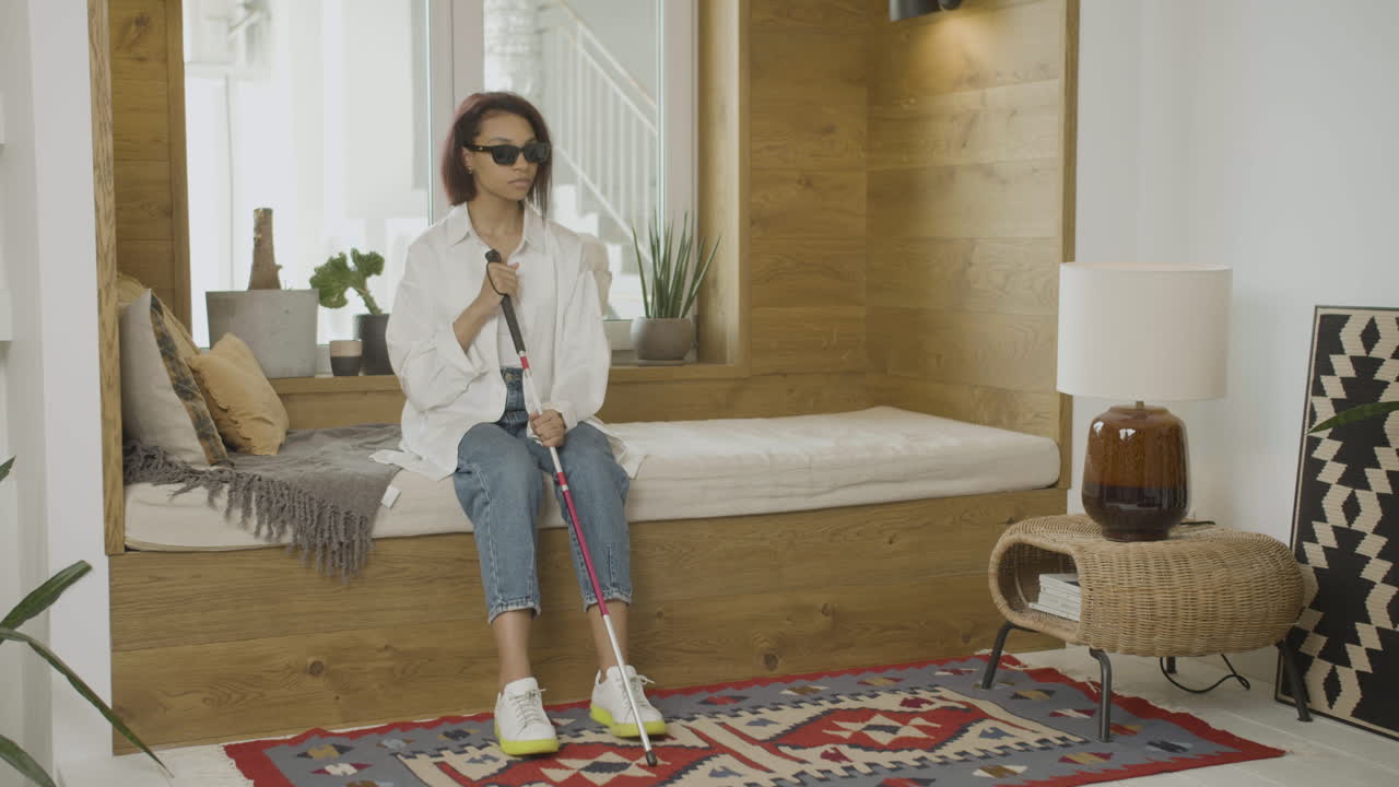 передний вид молодой слепой женщины, сидящей на кровати