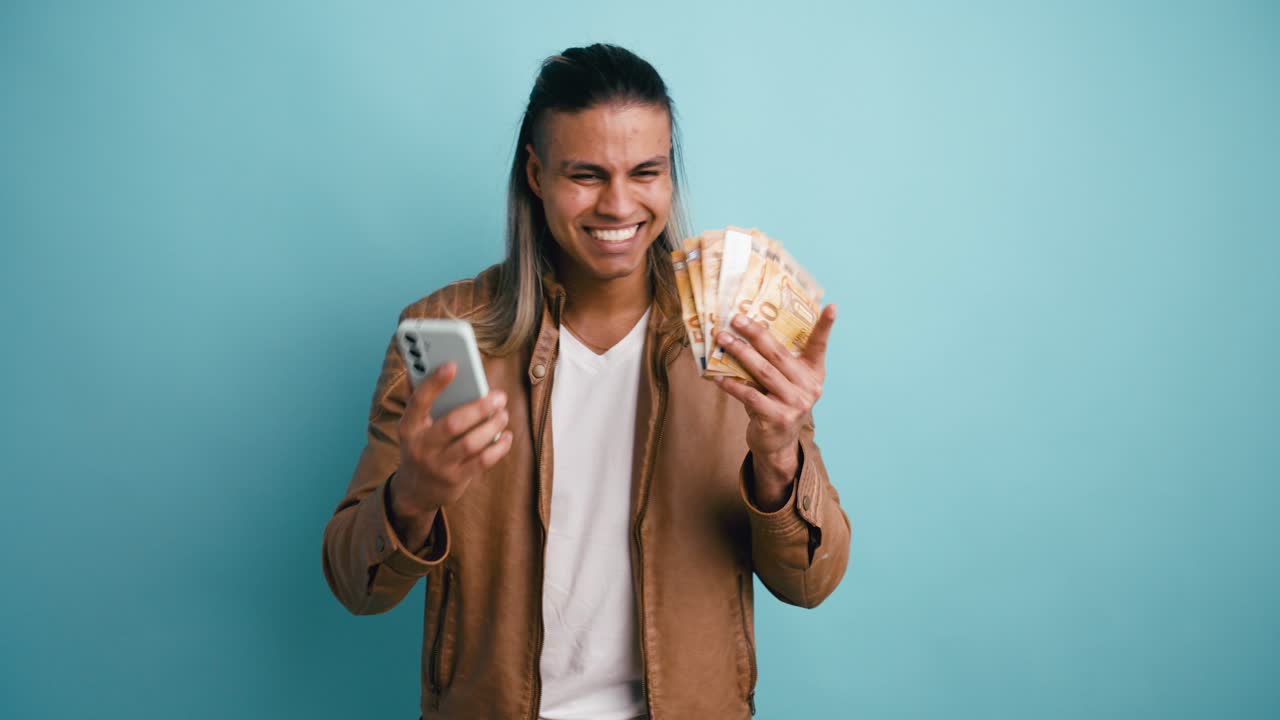 Happy Young Man Holding Smartphone and Euro Banknotes