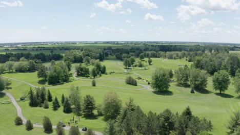 aerial view of golf course, fairways, tee boxes, sand traps, greens and carts on path before tournament begins