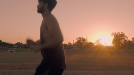 Indian-guy-running-and-trainning-for-cardio-exercise-on-public-park-during-sunset