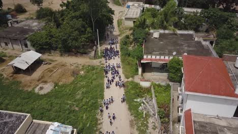 Close-Up-Aerial-Drone-Footage-of-Children-walking-to-School-in-a-Village-in-India,-Asia