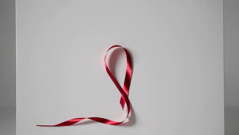 red awareness ribbon on white background