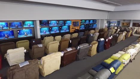 Drone-shot-inside-a-furniture-store,-with-TV's-and-recliners