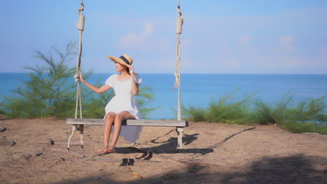 An-attractive-woman-on-a-giant-makeshift-swing-overlooking-the-tropical-ocean-horizon