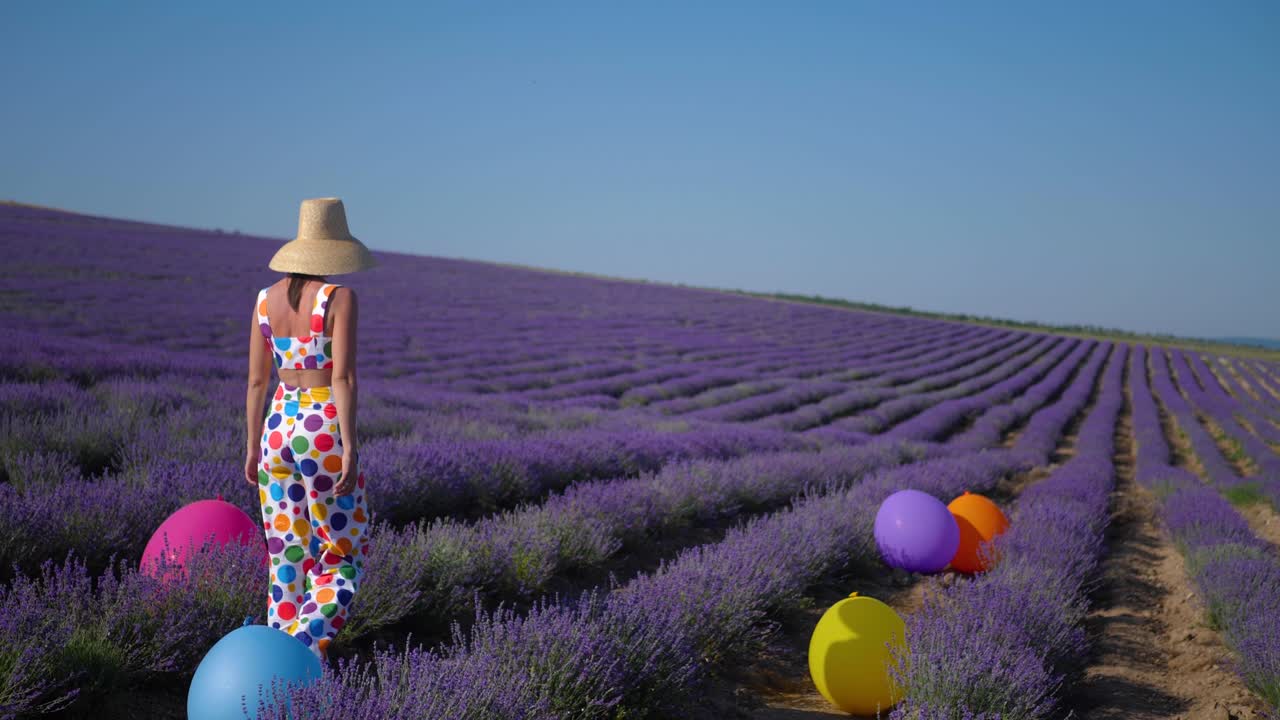 원과 모자를 가진 다채로운 의상을 입은 여자가 큰 부풀이 모자를 들고 있습니다.