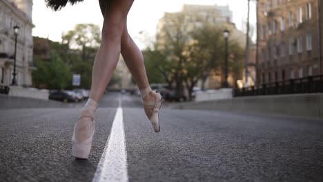 Elegante-Joven-Bailarina-De-Ballet-En-La-Calle-En-Una-Carretera-Vacía.-Pisar-De-Puntillas-En-Punta.-Primer-Plano-De-Las-Piernas-De-Una-Bailarina.-Camara-Lenta