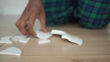 broken plate on a wooden floor with a person in the background