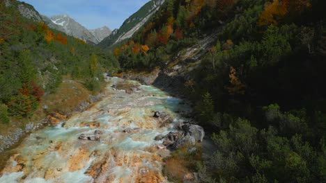 vuelo de un avión no tripulado sobre el colorido río karwendelbach en las montañas karwendel de austria tirol, muy cerca de scharnitz, grabado en otoño