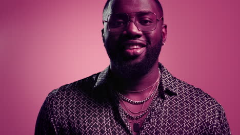 african american man laughing in studio. afro guy smiling on pink background