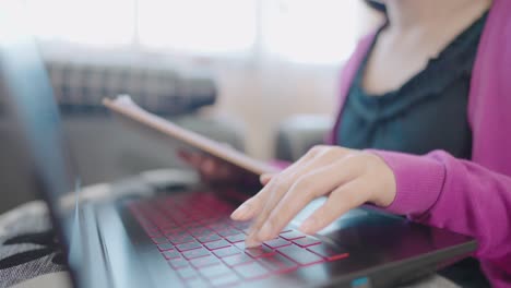 a close-up woman sitting on a sofa press to type information computer laptop for shopping online at home