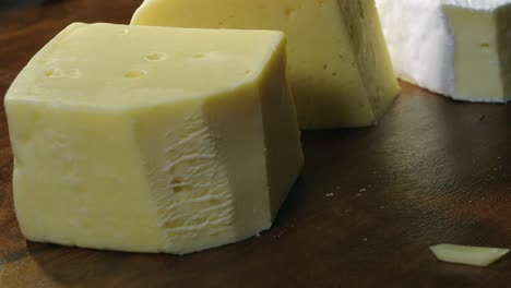 primer plano: una rebanada de queso suizo se coloca en una galleta sobre una tabla de madera