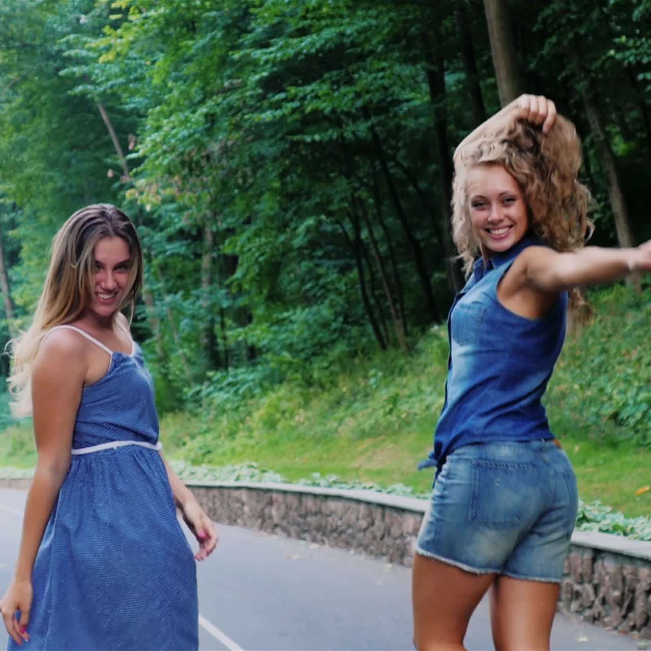 Giovani donne spensierate camminano lungo la strada nel parco