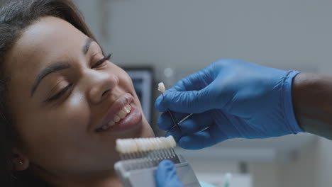 dentista que coincide con el tono de los dientes para el paciente