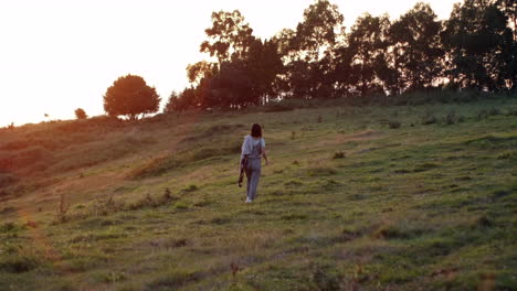 Woman's-silhouette-on-green-hill-near-forest