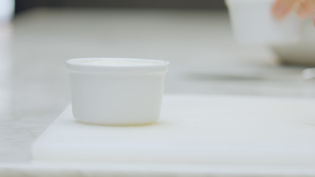 Close-up of a chef placing a ceramic mold on a chopping board