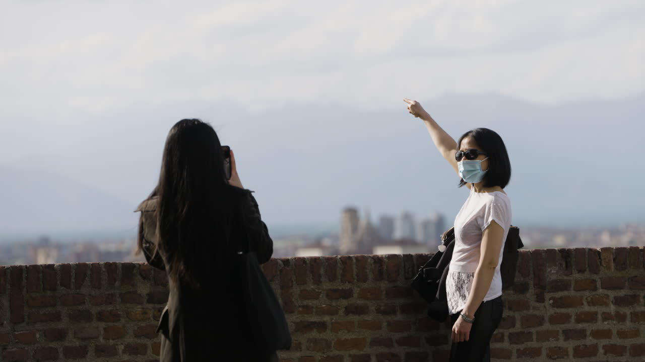 멋진 경치를 배경으로 사진을 찍는 여성 관광객