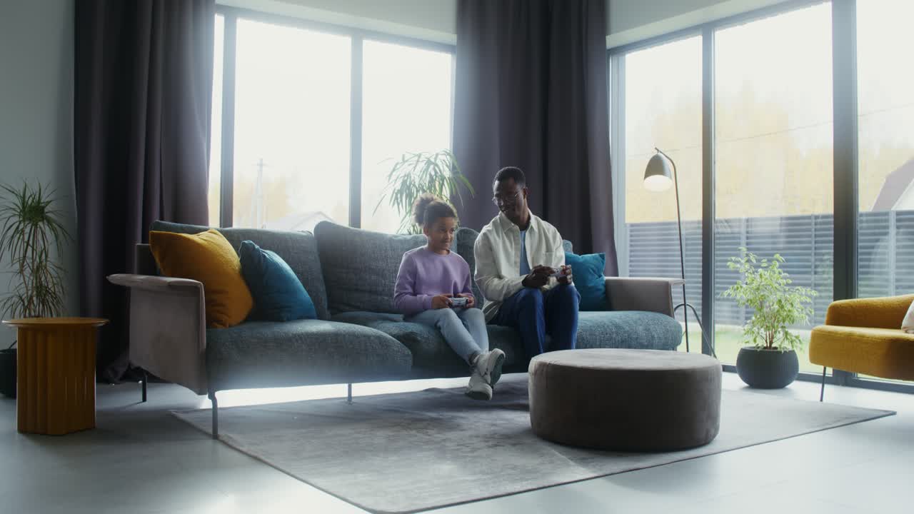 Father and Daughter Playing Video Games in the Living Room