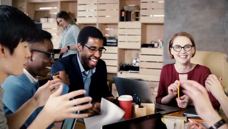 multi ethnic team working on new project ideas. happy office colleagues smiling at brainstorming business meeting. 4k