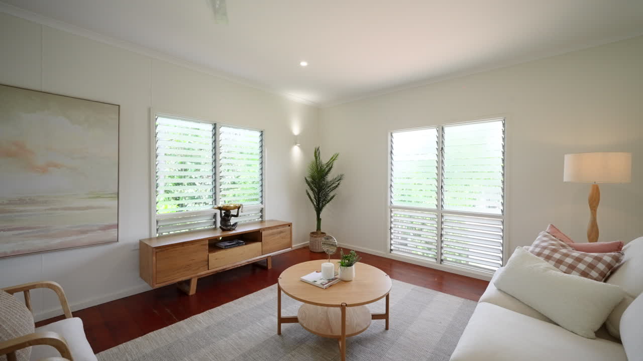 居心地の良い中性ベージュ色の家具の座席とアートで高層の近代的なラウンジルームを明らかにします