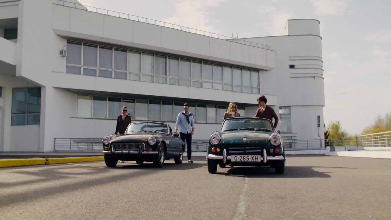 Friends enjoying vintage cars in a modern parking lot