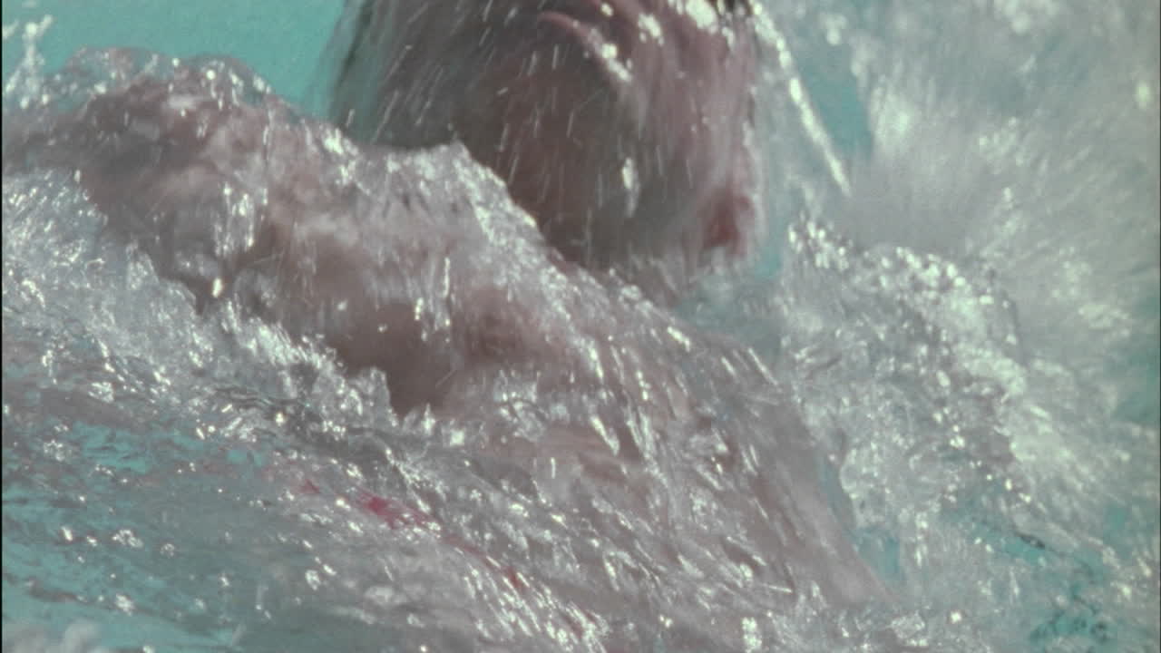 한 남자가 수영장에서 배영 스타일로 수영한다