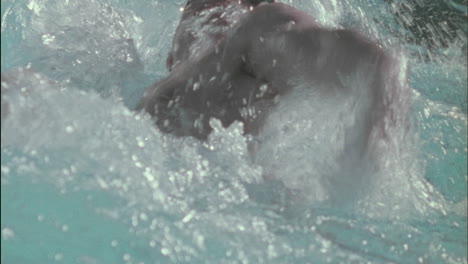 un hombre nada estilo espalda en una piscina