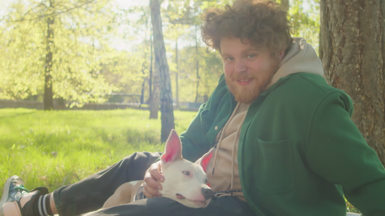 Man and His Puppy Enjoying a Sunny Day in the Park