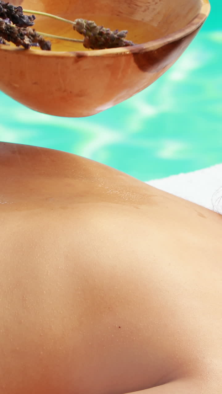 terapeuta de belleza frotando las espaldas de las mujeres con lavanda