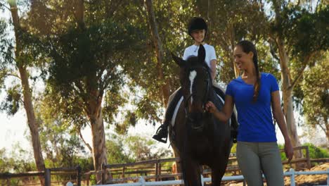 Mother-assisting-daughter-during-horse-riding-4k