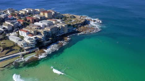 buildings at ben buckler suburb with surfers surfing in the ocean at bondi, new south wales, australia