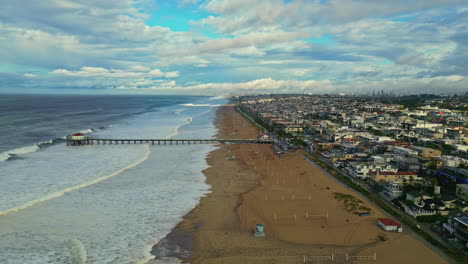 grandes olas rodando en la playa de manhattan en un día parcialmente nublado en los ángeles