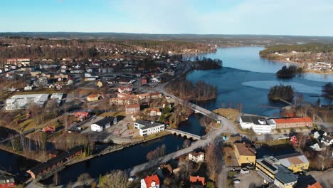 ascending aerial shot of rural swedish village during sunny day in autumn