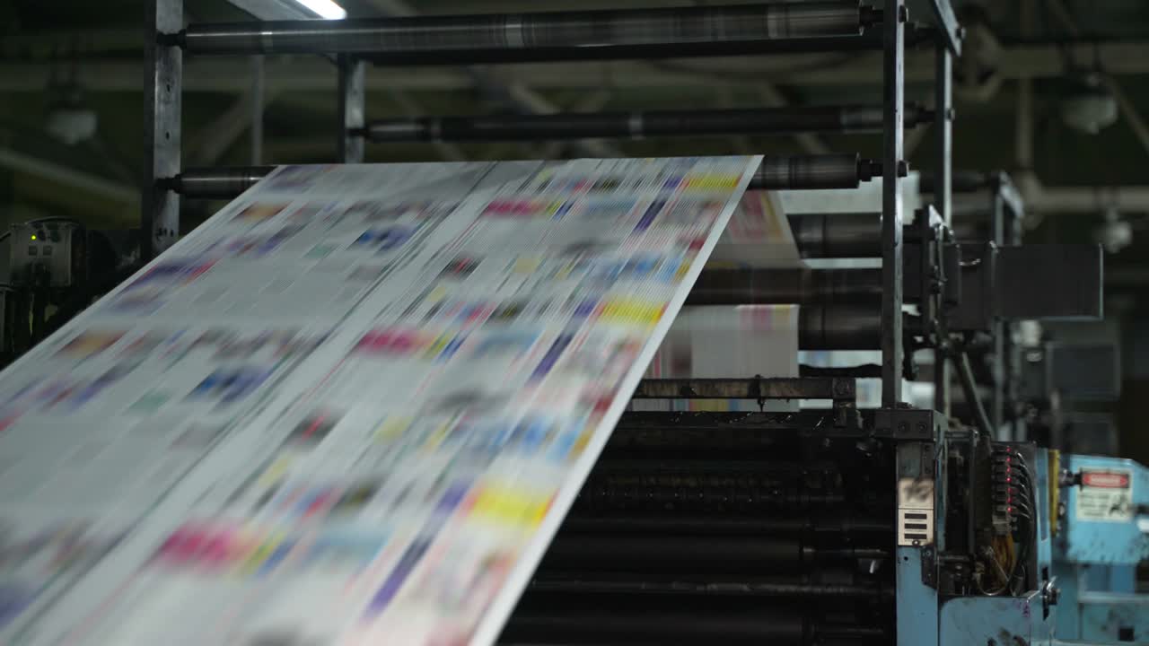 Color printing of newspapers on large machines, conveyor. Rolls of paper are drawn across the printing press. Printing house. Media, article, headline, daily news, print edition, journalism, politics