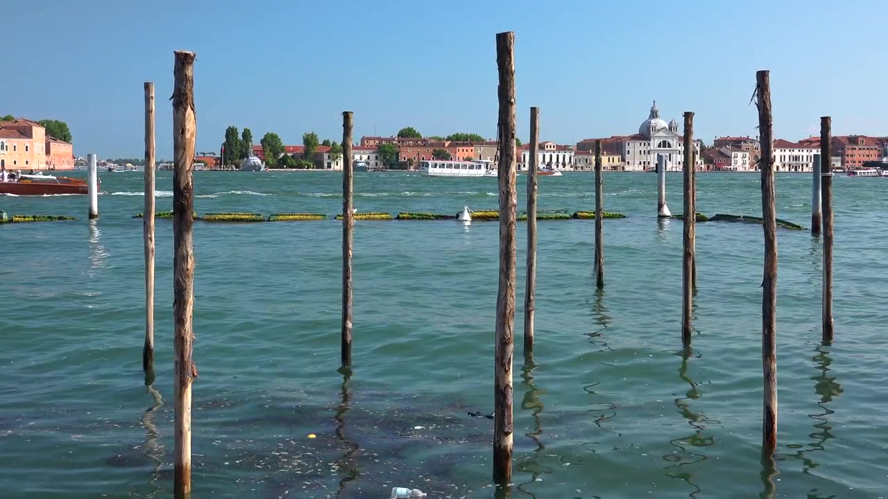 Briccole in legno nella Laguna di Venezia con barche di passaggio