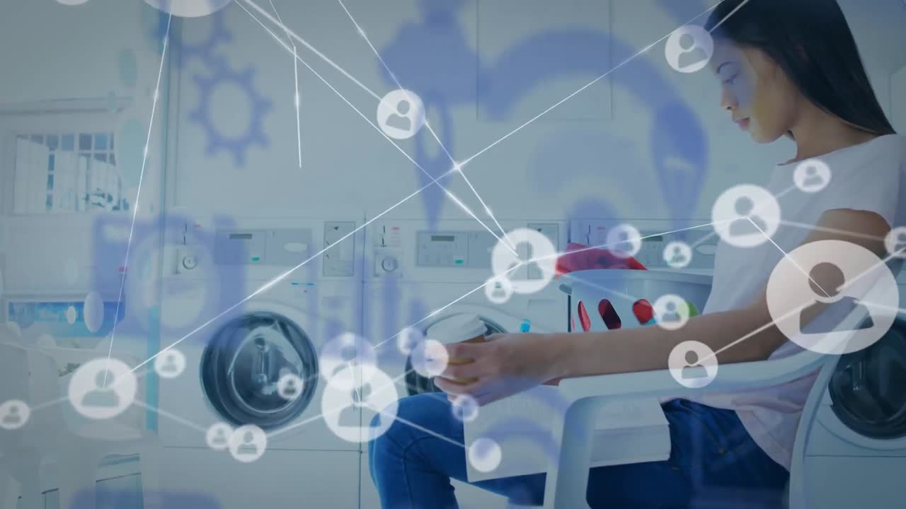 네트워크 아이콘과 함께 세탁소에서 기다리는 동안 노트북에서 일하는 두 인종의 여성의 비디오