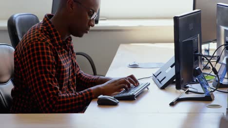 vista lateral de un joven hombre de negocios negro trabajando en un escritorio en una oficina moderna 4k