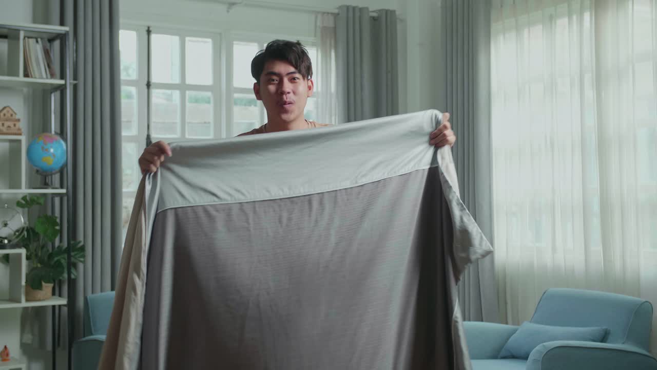 Asian Man Shows Trick With Disappearing While Recording Video Content For Social Networks In Cozy Room