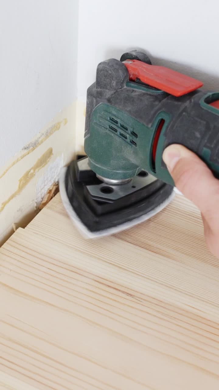 Levigatura manuale del legno in una ristrutturazione fai da te con attenzione alla precisione.