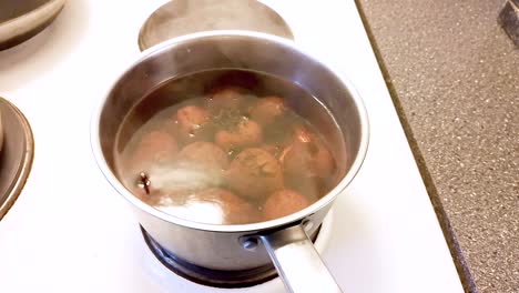 cocinar remolachas en agua hirviendo, vegano cocinando alimentos saludables - mano de primer plano