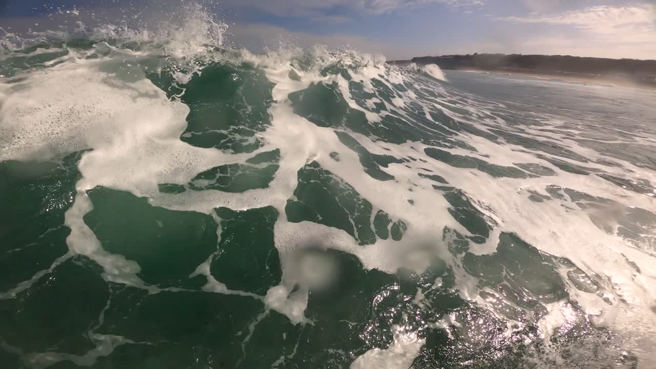 surfista en la ola del océano azul atacando el labio con fuertes chasquidos