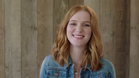 young stylish red head woman close up portrait of beautiful girl laughing cheerful at camera wearing denim jacket wooden background